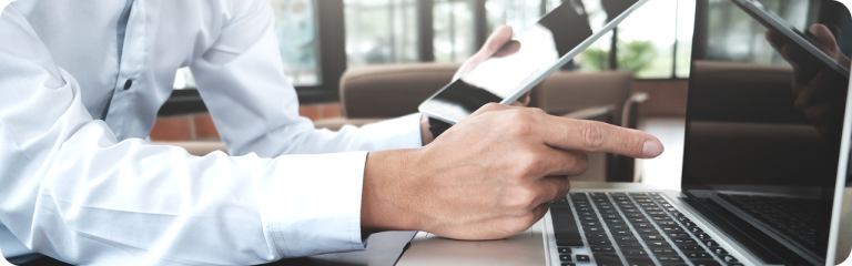 Ejecutivo evaluando opciones de ERP en laptop y tablet para tomar una decisión de software empresarial