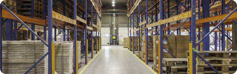 Interior de almacén con estanterías industriales y pallets organizados, ilustrando el control de stock en empresas uruguayas con un ERP